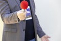 Journalist at news event, press conference or media interview holding microphone with copy space. Broadcast journalism concept.