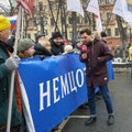 Reporter of the Russian TV Rain channel Aleksei Korostelev interviewing demonstrators carrying a political banner