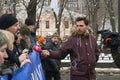 Reporter of the Russian TV Rain channel Aleksei Korostelev interviewing demonstrators carrying a political banner