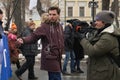 Reporter of the Russian TV Rain channel Aleksei Korostelev interviewing demonstrators carrying a political banner