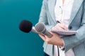 News reporter or TV journalist at press conference, holding microphone and writing notes Royalty Free Stock Photo