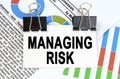 Among the reporting charts and diagrams is a plate with the inscription - MANAGING RISK Royalty Free Stock Photo