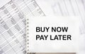 On the reports there is a notepad with the text BUY NOW, PAY LATER. Business concept Royalty Free Stock Photo
