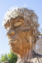 representation of a large human head made from pieces of tree bark