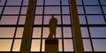 Reproduction Roman statue located in a large window with a sunset