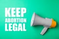 Reproductive rights protest. Megaphone with slogan Keep Abortion Legal on aquamarine color background