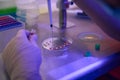 Reproductology laboratory worker adding cells on cleavage dish