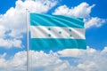 Honduras national flag waving in the wind on clouds sky. High quality fabric. International relations concept