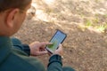 Man using a smartphone with an online map in search of the right trail in the forest. Royalty Free Stock Photo