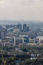 Panoramic view on Almaty city from mount Kok Tobe park. Cityscape at spring day. Haze smog above town, ecology problem Royalty Free Stock Photo