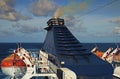 Rescue boat or lifeboat on deck of a cruise ship. Orange lifeboat on mounting bracket. Sea and blue sky with clouds in the Royalty Free Stock Photo