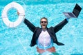 Rescue business. Business man in suit hold laptop and rescue lifebuoy in swim pool. Rescue swimming ring for businessman