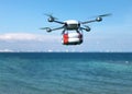 Rescue drone with lifebuoy flying over the ocean. Royalty Free Stock Photo