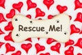 Rescue me message on a wood dog bone with paw print with red hearts on white fabric