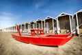 Rescue red rowing boat. Huts wooden on the beach. Royalty Free Stock Photo