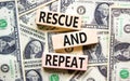 Rescue and repeat symbol. Concept words Rescue and repeat on wooden block on a beautiful background from dollar bills. Dollar Royalty Free Stock Photo