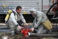 Rescue team training of chemical decontamination: rescuer in a protective ensemble turning a valve of a fire hydrant