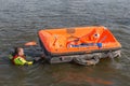 Rescue worker showing life raft in harbor Urk, the Netherlands