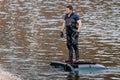 Rescue worker standing on top of roof of submerged car driven into River Avon by accident in Stratford upon Avon, Warwickshire, UK