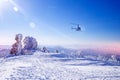 Rescuers looking for missing skiers and snowboarders in mountains, snowy forest with help of helicopter. Rescue Royalty Free Stock Photo