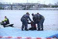 Rescuers taking sufferer from a rescue motorboat helping him to get to the first aid post