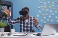 Research agency amazed surprised employee playing with VR technology while in office space.