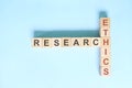 Research ethics concept. Crossword puzzle flat lay typography in blue background