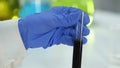 Research lab assistant examining sample of raw oil for impurities and sediments