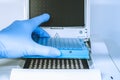 Research scientist putting test 96 well platte into real-time pcr machine Royalty Free Stock Photo