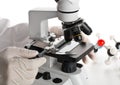 Research scientist working with specimen plate on microscope wit