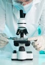 Research scientist working with specimen plate on microscope wit Royalty Free Stock Photo