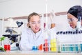 Research teams Cacausian and African female, Two  scientist in protective glasses looking and testing tube chemical in laboratory Royalty Free Stock Photo