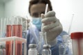 Closeup of lab tubes,flasks and woman scientist who undertaking research