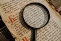 Researcher explores antique book with magnifier. Scientific translation of literature. Investigating manuscript with Royalty Free Stock Photo