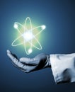 Researcher or scientist with rubber glove holding glowing atom m