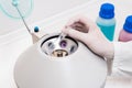 Researcher using laboratory equipment, putting sample tube in centrifuge machine to to do the lab test. Royalty Free Stock Photo