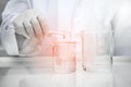Researcher in white lab coat holding cylinder and poring water i Royalty Free Stock Photo