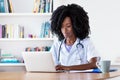 Researching african american medical female student at computer