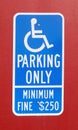 Reserved handicapped parking sign mounted on red wall. Royalty Free Stock Photo