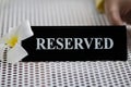 Reserved metal black plate in a restaurant. Reserved metal plate On the white table. vintage photo processing. close up of a Royalty Free Stock Photo