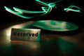 Reserved sign on the table. A tag of reservation placed on the wood table. Metal tag with reservation on dark. Reserved table in a Royalty Free Stock Photo