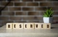 Reserved word wooden cubes on pink background Royalty Free Stock Photo