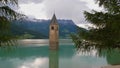 Reservoir Reschensee, South Tyrol, Italy with lone standing steeple in the water in early summer.