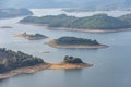 The reservoir under the blue sky and white clouds is surrounded by mountains and forests Royalty Free Stock Photo