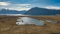 The way to Lake Ohau and the southern alps through alpine grasses and tundra terrain