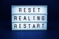 Reset Realing Restart letterboard text on LED Lightbox on blue background Royalty Free Stock Photo