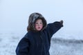 A resident of the tundra, indigenous residents of the Far North, tundra, open area, Boy shows direction with his hand