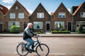 Resident of the village of Volendam by bike in front of the typical traditional houses, Netherlands.