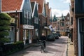 Resident of the village of Volendam by bike in front of the typical traditional houses, Netherlands.