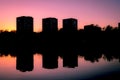 Residental houses at dusk. Residential neighborhoods of the city in the sunset light. City buildings, lake or pond and purple sky